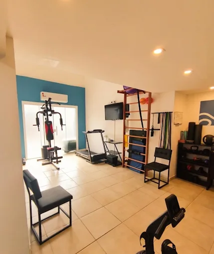 Espaço de treino com esteira, estação de musculação e espaldar